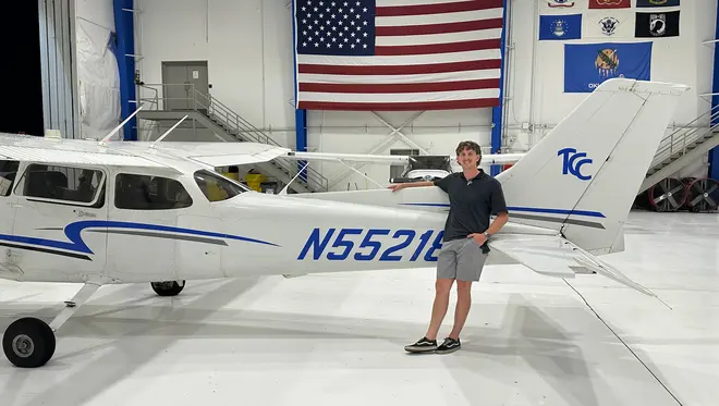 Grant Casebeer stands in front of a plane