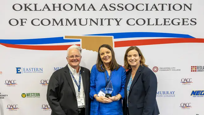 Angela Sivadon, Mary Cantrell, and Leigh Goodson are smiling while Cantrell is holding a Hall of Fame trophy.