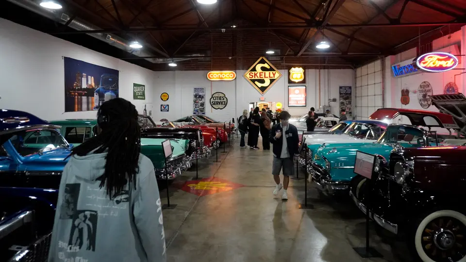 Students walk in between classic cars at the Route 66 Auto Museum in Sapulpa