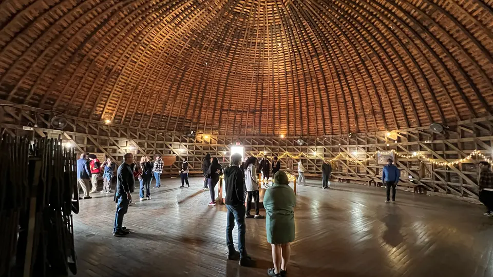 People stand in various places inside the Round Barn in Arcadia