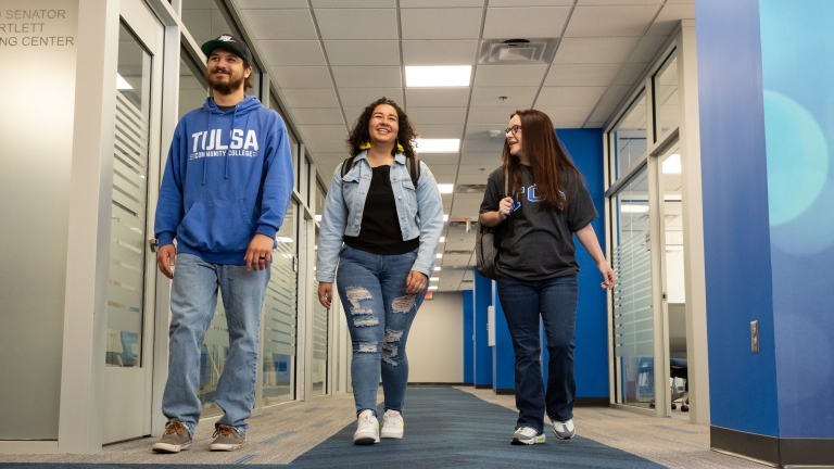 Three students walking down a hallway