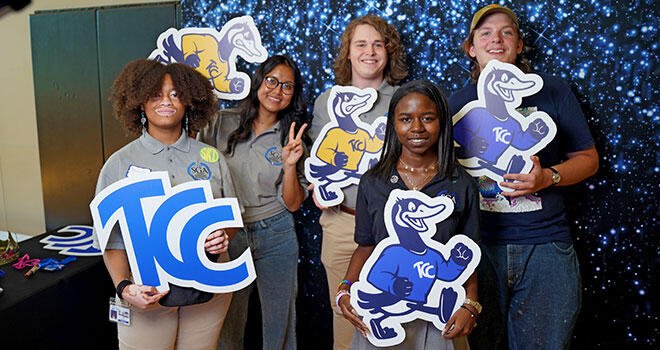 Student Government Association members holding TCC and mascot signs representing campus involvement.